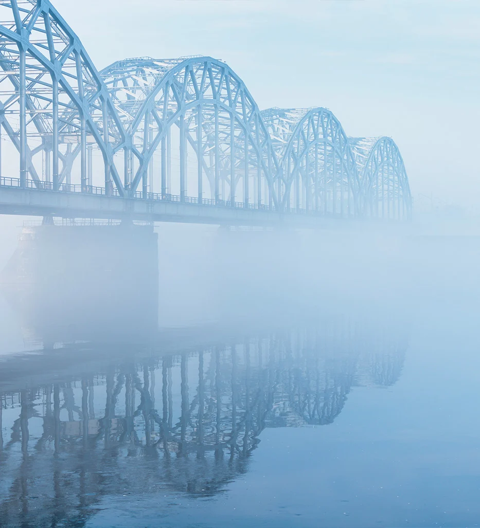 A bridge spanning open water beneath a broad sky.