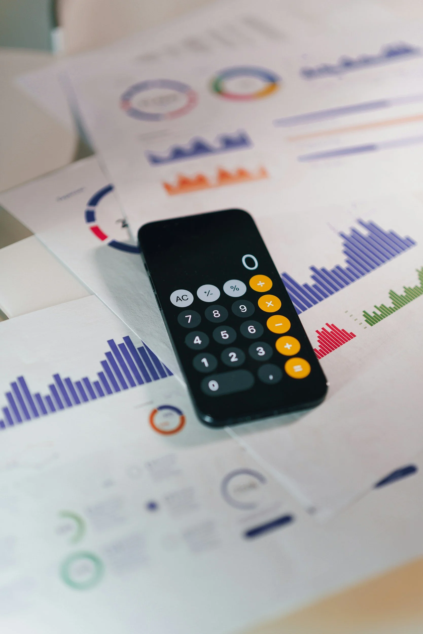 Calculator resting on financial charts and planning papers