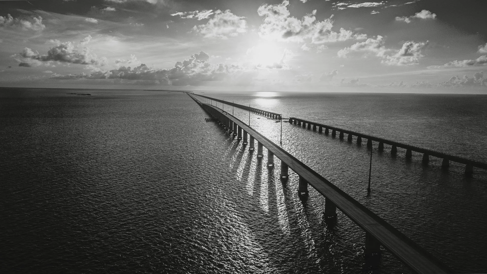 Aerial view of a long bridge crossing open ocean water