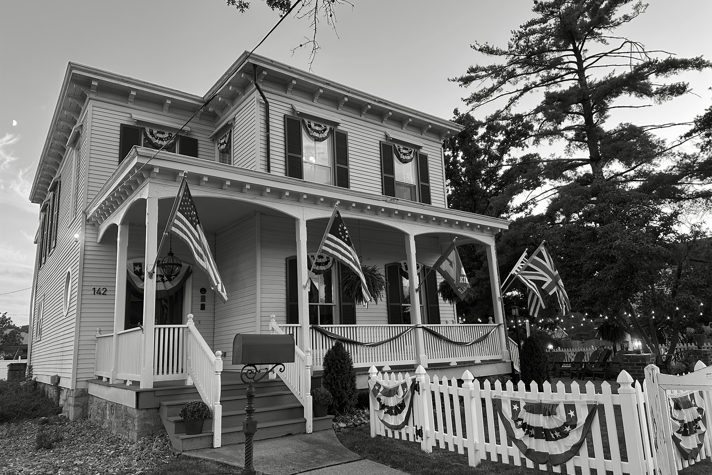 Historic house exterior framed by mature trees
